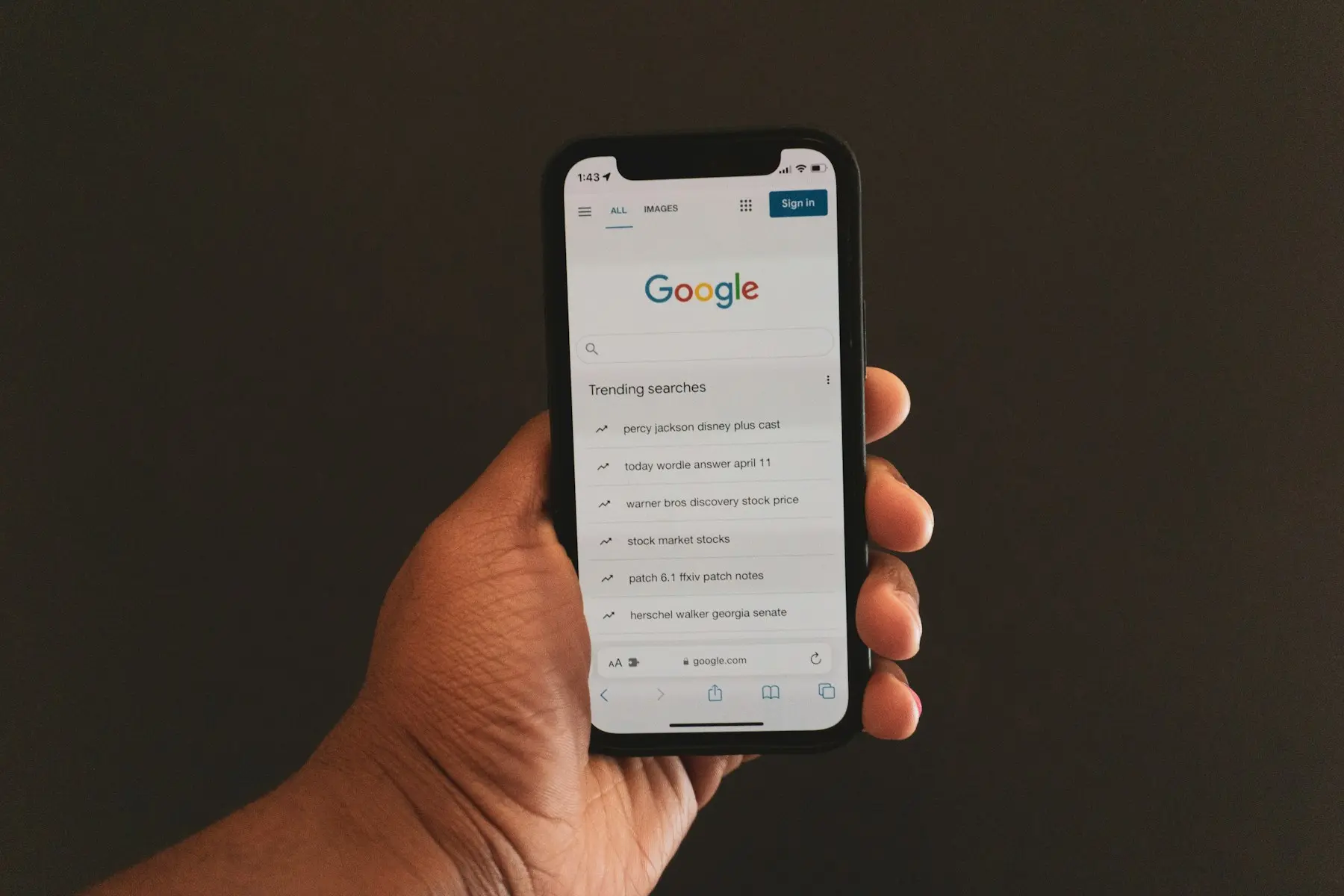 Hand holding a smartphone open on a Google search page
