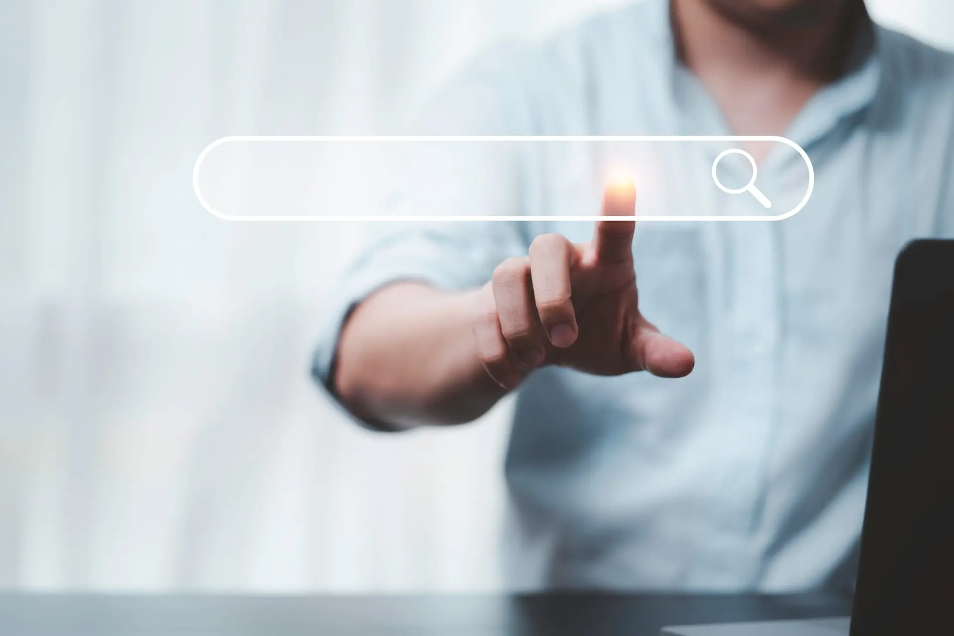 Person touching a glowing search bar on a virtual screen